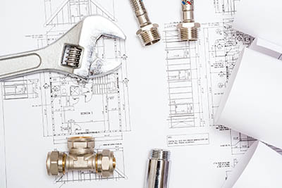 Plumbing tools and fittings on top of a blueprint