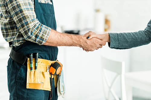 Ballarat plumber with tools shaking hands with client